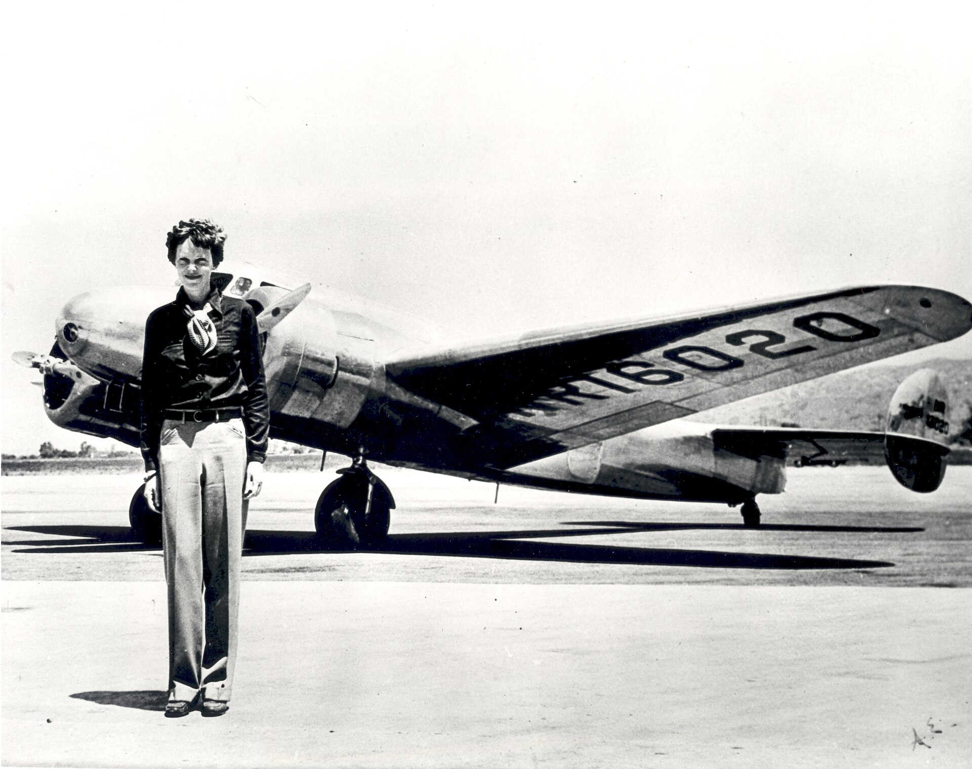 Amelia Earhart standing before the Lockheed Electra in which she disappeared in 1937.